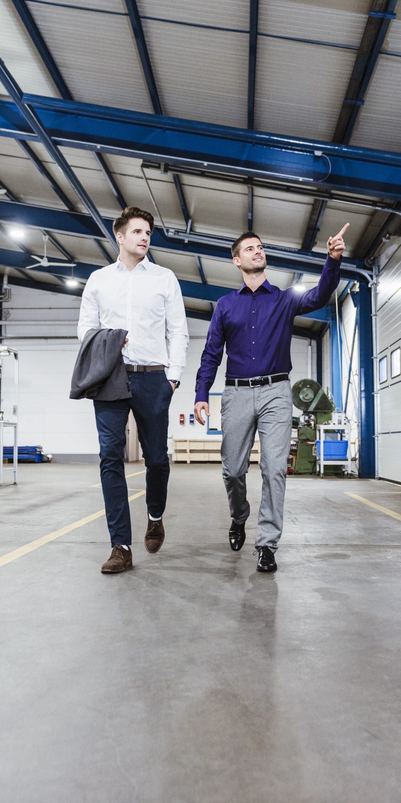 Two businessmen walking through shop floor, talking